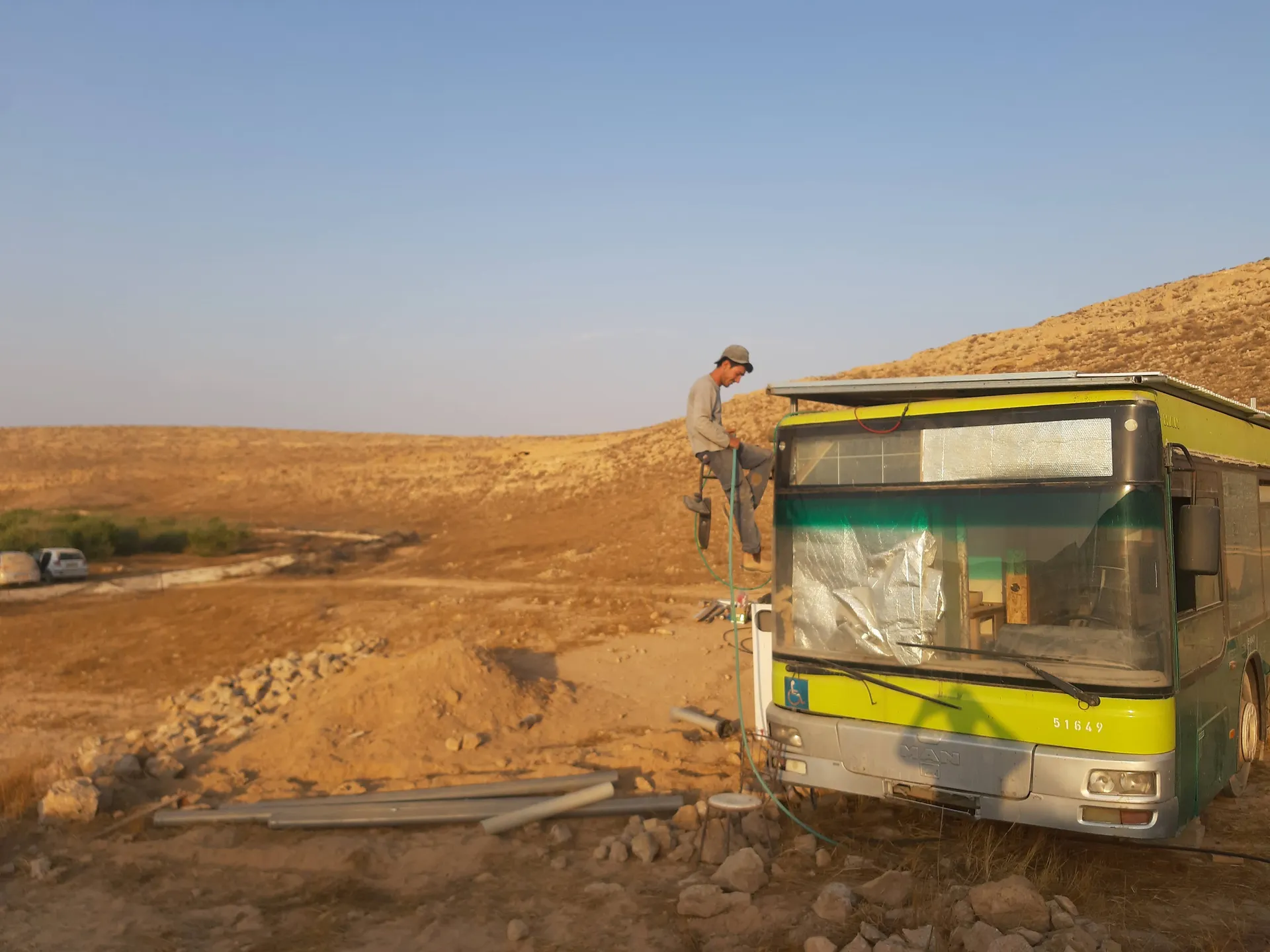 יותם עושה עבודות חשמל מחוץ לאוטובוס